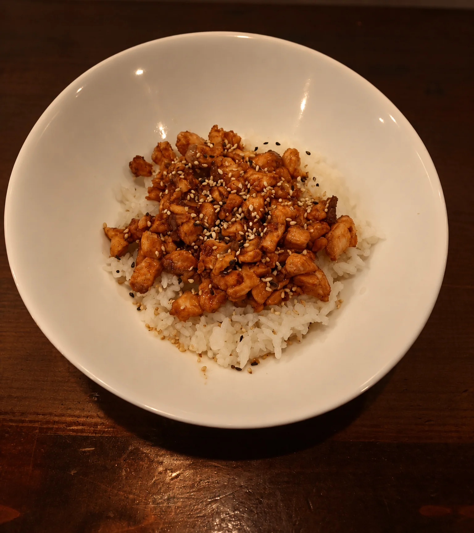 CH9 : bol blanc de riz garni sur une table en bois sombre, lumière du soir.